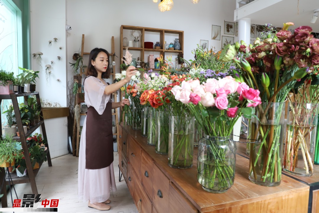 王黎媛是一名河南姑娘，在昆明念完大學(xué)后，就再也舍不下春城的藍(lán)天陽(yáng)光、青山碧水，更舍不下這里的四時(shí)繁花，于是就干脆留了下來(lái)，成了一名媒體人。2017年的時(shí)候又毅然辭去工作，創(chuàng)業(yè)開(kāi)起了花店，成了都市里的一名“花房姑娘”。圖為王黎媛在自己的花店中整理鮮花。新華網(wǎng) 周亞平/攝 念新洪/文